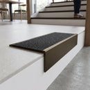 Solid brass stair nosing 59mm raked back slimline in antique bronze finish with black olympic grip anti-slip insert, fitted to a stair tread
