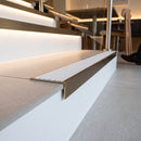 Solid brass stair nosing 59mm raked back slimline in antique bronze finish with cloud castellated anti-slip insert, fitted to a stair tread