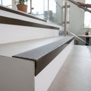 Solid brass stair nosing 59mm raked back slimline in antique bronze finish with nimbus castellated anti-slip insert, fitted to a stair tread