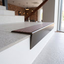 Solid brass stair nosing 59mm raked back slimline in antique bronze finish with rustic castellated anti-slip insert, fitted to a stair tread