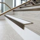 Solid brass stair nosing 59mm raked back slimline in antique bronze finish with white castellated anti-slip insert, fitted to a stair tread