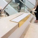 Solid brass stair nosing 59mm raked back slimline in polished brass finish with cloud castellated anti-slip insert, fitted to a stair tread