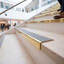 Solid brass stair nosing 59mm raked back slimline in polished brass finish with flint castellated anti-slip insert, fitted to a stair tread