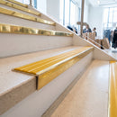 Solid brass stair nosing 59mm raked back slimline in polished brass finish with gold castellated anti-slip insert, fitted to a stair tread