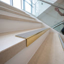 Solid brass stair nosing 59mm raked back slimline in polished brass finish with light grey castellated anti-slip insert, fitted to a stair tread