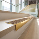 Solid brass stair nosing 59mm raked back slimline in polished brass finish with olive castellated anti-slip insert, fitted to a stair tread
