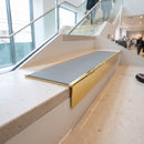 Solid brass stair nosing 59mm raked back slimline in polished brass finish with polar grey smooth textured anti-slip insert, fitted to a stair tread