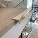 Solid brass stair nosing 59mm raked back slimline in polished brass finish with polar grey castellated anti-slip insert, fitted to a stair tread