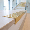 Solid brass stair nosing 59mm raked back slimline in polished brass finish with polished brass anti-slip insert, fitted to a stair tread