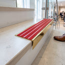 Solid brass stair nosing 59mm raked back slimline in polished brass finish with poppy castellated anti-slip insert, fitted to a stair tread