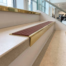 Solid brass stair nosing 59mm raked back slimline in polished brass finish with rustic castellated anti-slip insert, fitted to a stair tread