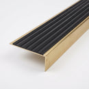 Solid brass stair nosing 59mm raked back slimline profile in polished brass finish with black castellated insert, studio view