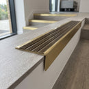 Solid brass stair nosing 59mm raked back slimline in satin brass finish with antique brass anti-slip insert, fitted to a stair tread