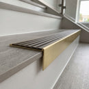 Solid brass stair nosing 59mm raked back slimline in satin brass finish with antique bronze anti-slip insert, fitted to a stair tread