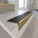 Solid brass stair nosing 59mm raked back slimline in satin brass finish with black castellated anti-slip insert, fitted to a stair tread