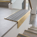 Solid brass stair nosing 59mm raked back slimline in satin brass finish with cloud castellated anti-slip insert, fitted to a stair tread