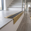 Solid brass stair nosing 59mm raked back slimline in satin brass finish with granite castellated anti-slip insert, fitted to a stair tread
