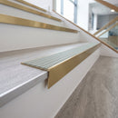 Solid brass stair nosing 59mm raked back slimline in satin brass finish with jade castellated anti-slip insert, fitted to a stair tread