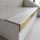 Solid brass stair nosing 59mm raked back slimline in satin brass finish with light grey castellated anti-slip insert, fitted to a stair tread
