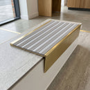 Solid brass stair nosing 59mm raked back slimline in satin brass finish with nimbus castellated anti-slip insert, fitted to a stair tread