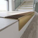 Solid brass stair nosing 59mm raked back slimline in satin brass finish with olive castellated anti-slip insert, fitted to a stair tread