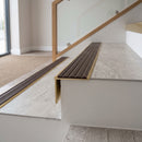 Solid brass stair nosing 59mm raked back slimline in satin brass finish with peat castellated anti-slip insert, fitted to a stair tread