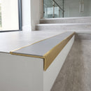 Solid brass stair nosing 59mm raked back slimline in satin brass finish with polar grey smooth textured anti-slip insert, fitted to a stair tread
