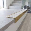 Solid brass stair nosing 59mm raked back slimline in satin brass finish with polar grey castellated anti-slip insert, fitted to a stair tread