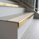 Solid brass stair nosing 59mm raked back slimline in satin brass finish with porth stone smooth textured anti-slip insert, fitted to a stair tread