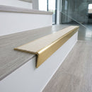 Solid brass stair nosing 59mm raked back slimline in satin brass finish with porth stone castellated anti-slip insert, fitted to a stair tread