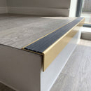 Solid brass stair nosing 59mm raked back slimline in satin brass finish with regency castellated anti-slip insert, fitted to a stair tread