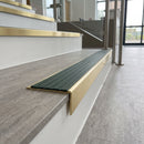 Solid brass stair nosing 59mm raked back slimline in satin brass finish with spruce castellated anti-slip insert, fitted to a stair tread