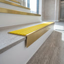 Solid brass stair nosing 59mm raked back slimline in satin brass finish with yellow castellated anti-slip insert, fitted to a stair tread