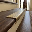 Solid brass stair nosing, 59.5mm tread with a 30mm raked-back front, in Antique Brass finish with Antique Brass insert, fitted to a staircase
