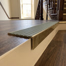 Solid brass stair nosing, 59.5mm tread with a 30mm raked-back front, in Antique Brass finish with Jade Castellated insert, fitted to a staircase