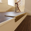Solid brass stair nosing, 59.5mm tread with a 30mm raked-back front, in Antique Brass finish with Light Grey Smooth Textured insert, fitted to a staircase