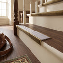 Solid brass stair nosing, 59.5mm tread with a 30mm raked-back front, in Antique Brass finish with Nimbus Castellated insert, fitted to a staircase