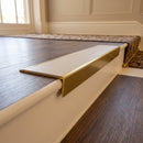 Solid brass stair nosing, 59.5mm tread with a 30mm raked-back front, in Antique Brass finish with Porth Stone Smooth Textured insert, fitted to a staircase