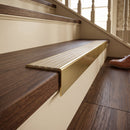 Solid brass stair nosing, 59.5mm tread with a 30mm raked-back front, in Antique Brass finish with Satin Brass insert, fitted to a staircase