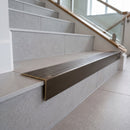 Solid brass stair nosing, 59.5mm tread with a 30mm raked-back front, in Antique Bronze finish with Antique Bronze insert, fitted to a staircase