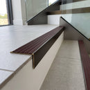 Solid brass stair nosing, 59.5mm tread with a 30mm raked-back front, in Antique Bronze finish with Claret Castellated insert, fitted to a staircase