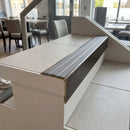 Solid brass stair nosing, 59.5mm tread with a 30mm raked-back front, in Antique Bronze finish with Flint Castellated insert, fitted to a staircase