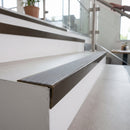 Solid brass stair nosing, 59.5mm tread with a 30mm raked-back front, in Antique Bronze finish with Nimbus Castellated insert, fitted to a staircase