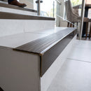Solid brass stair nosing, 59.5mm tread with a 30mm raked-back front, in Antique Bronze finish with Olive Castellated insert, fitted to a staircase