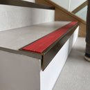 Solid brass stair nosing, 59.5mm tread with a 30mm raked-back front, in Antique Bronze finish with Poppy Castellated insert, fitted to a staircase