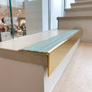 Solid brass stair nosing, 59.5mm tread with a 30mm raked-back front, in Polished Brass finish with Jade Castellated insert, fitted to a staircase
