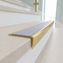 Solid brass stair nosing, 59.5mm tread with a 30mm raked-back front, in Polished Brass finish with Nimbus Castellated insert, fitted to a staircase