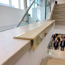 Solid brass stair nosing, 59.5mm tread with a 30mm raked-back front, in Polished Brass finish with Porth Stone Castellated insert, fitted to a staircase