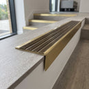 Solid brass stair nosing, 59.5mm tread with a 30mm raked-back front, in Satin Brass finish with Antique Brass insert, fitted to a staircase