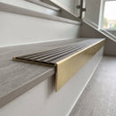 Solid brass stair nosing, 59.5mm tread with a 30mm raked-back front, in Satin Brass finish with Antique Bronze insert, fitted to a staircase